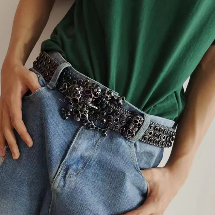 Cintura in pelle con fibbia a forma di teschio nero e borchie di strass
