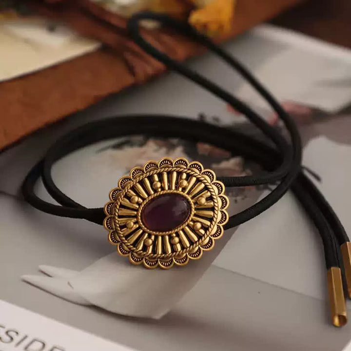 Cravatta Bolo in resina rosso scuro con medaglione in oro antico
