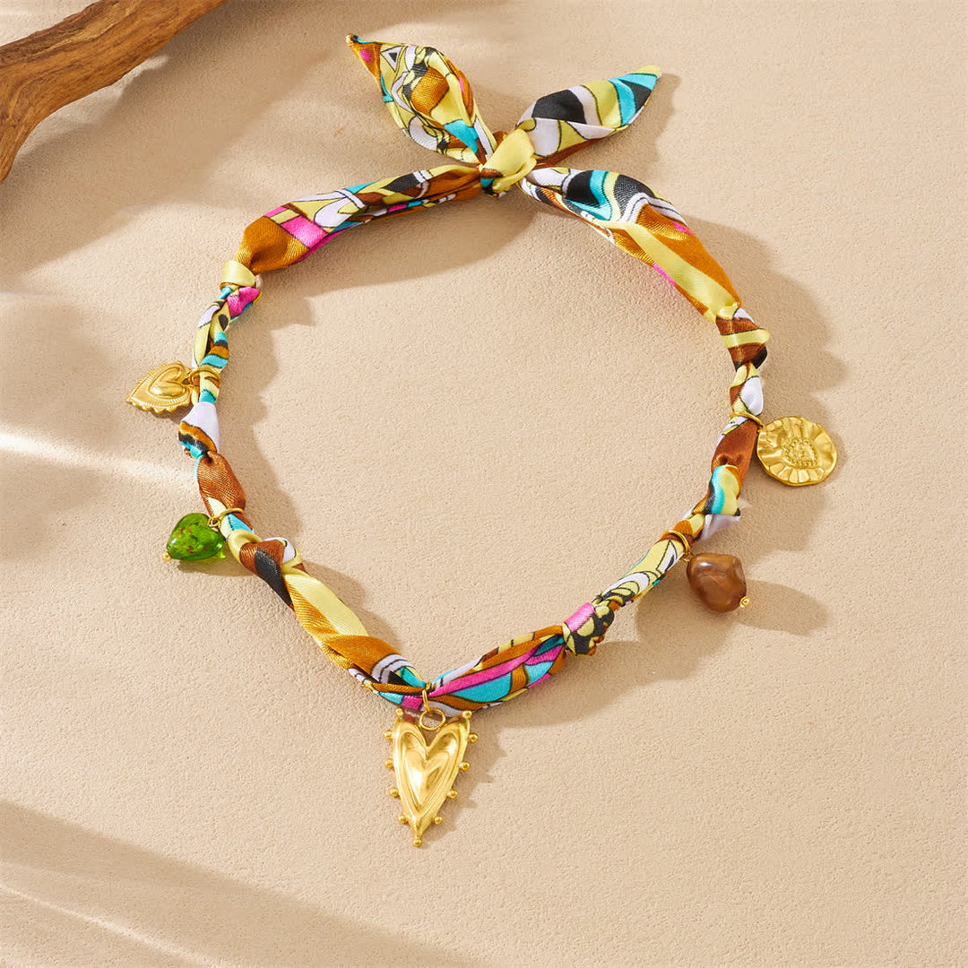 Collana con ciondolo a cuore dorato e sciarpa colorata annodata a mano. - image 1