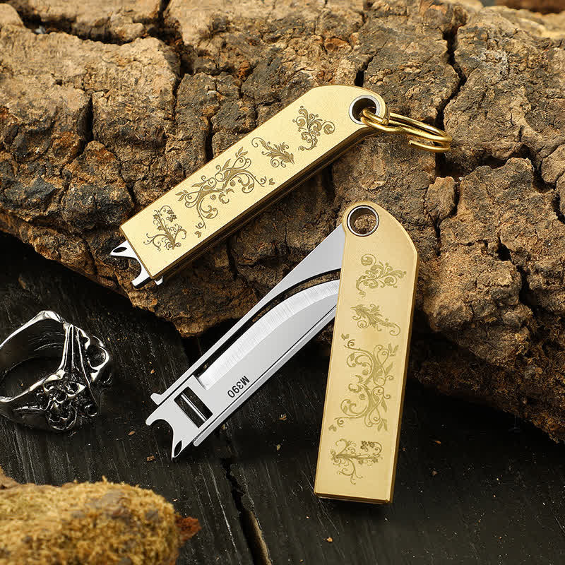 Portachiavi compatto ed elegante con coltello pieghevole in ottone e motivo dorato. - image 0