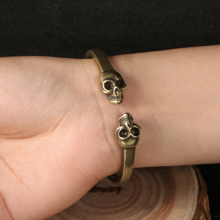 Bracciale rigido aperto in ottone massiccio con doppio teschio in bronzo gotico. - image 1