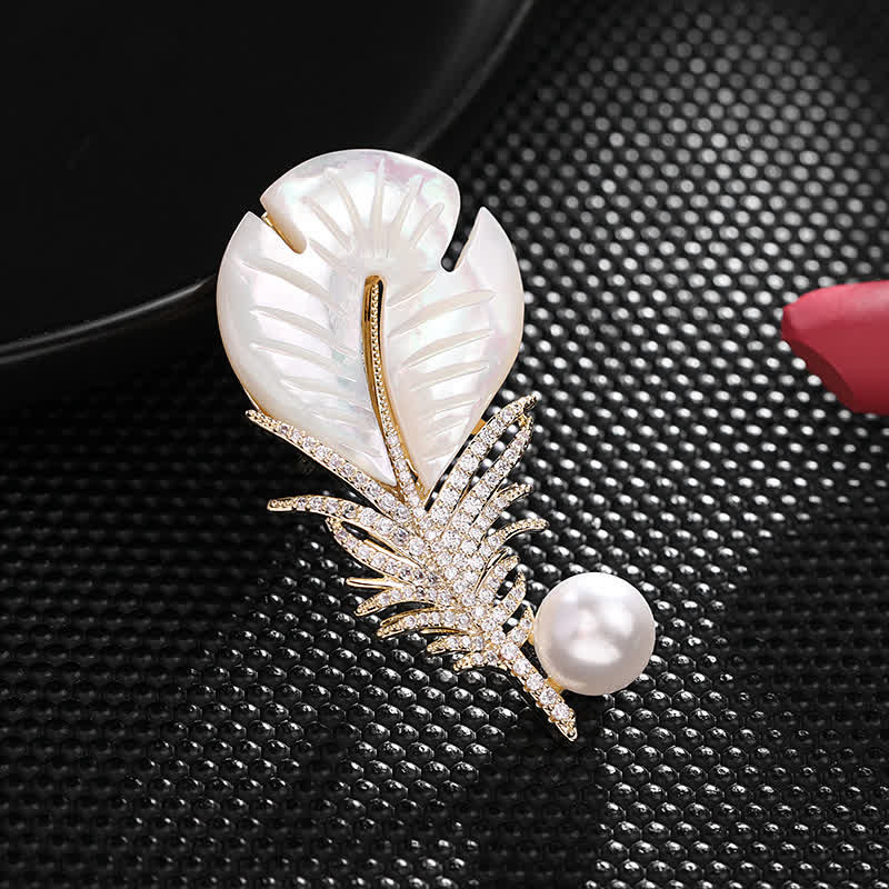 Spilla con piuma e conchiglia di perle da donna